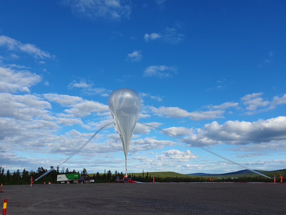 Riesiger Stratosphärenballon kurz vor dem Start. Im Hintergrund strahlend blauer Himmel mit schönen Wolken.