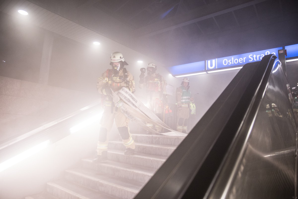 Feuerwehrmänner auf Treppe in U-Bahnhof