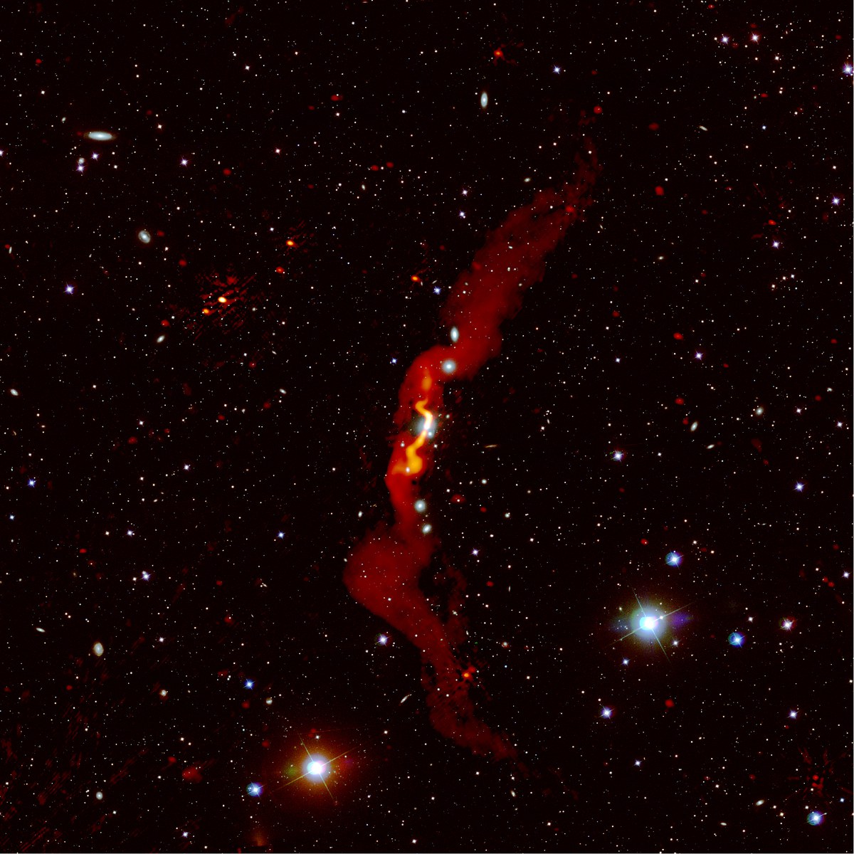 Die Radiogalaxie 3C31, die von Heesen et al (2018) mit LOFAR beobachtet wurde, ist rot über einem optischen Bild dargestellt. LOFAR konnte zeigen, dass die Radiogalaxie mehr als 3 Millionen Lichtjahre groß ist.